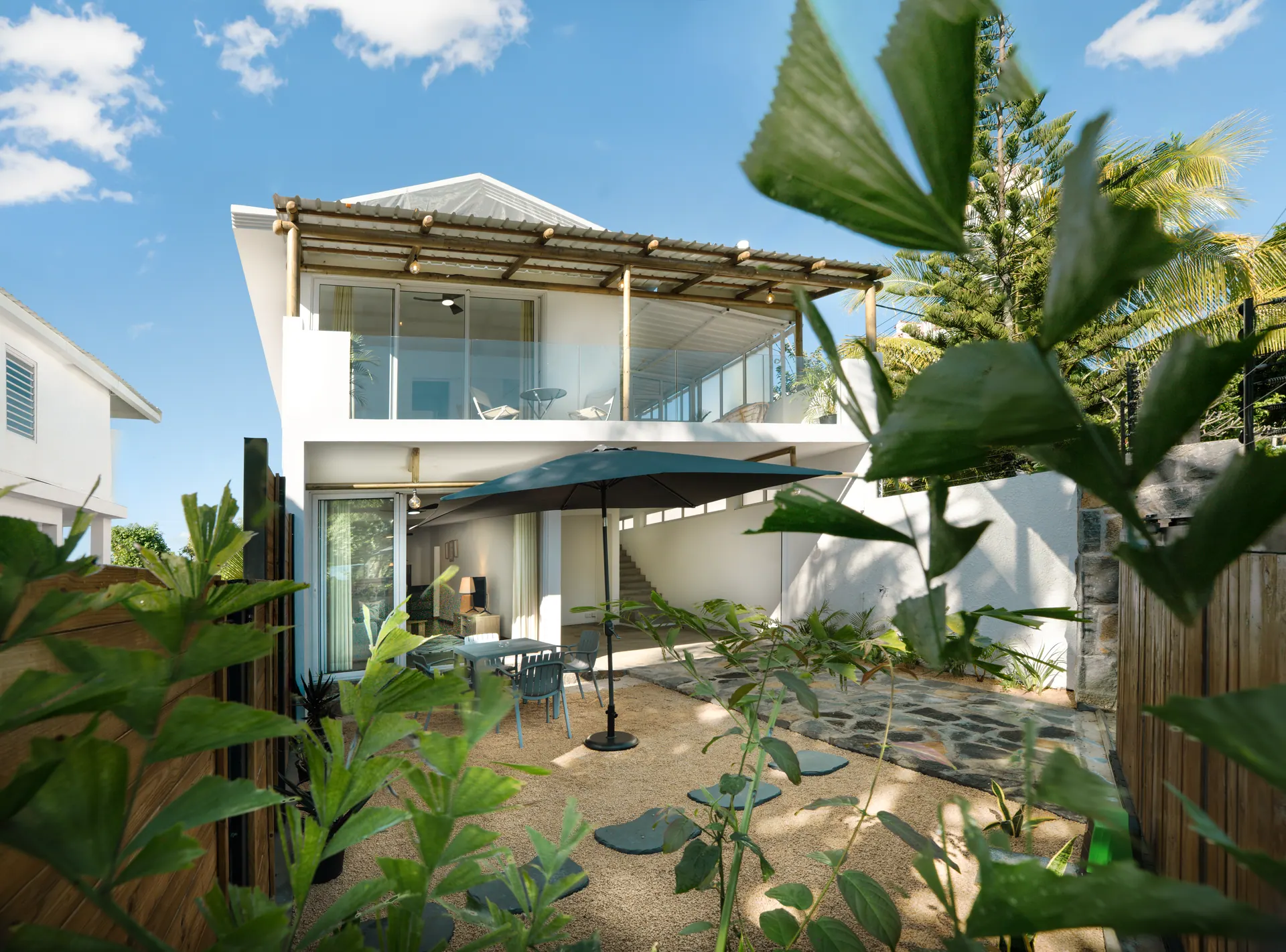Villa Belladonna, terrasse extérieure entourée de palmiers à Roches Noires, Île Maurice